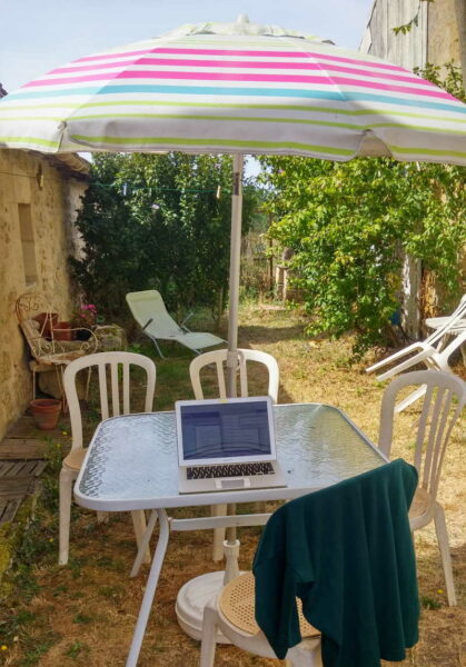 etätyö työpöytä puutarhassa, kannettava tietokone